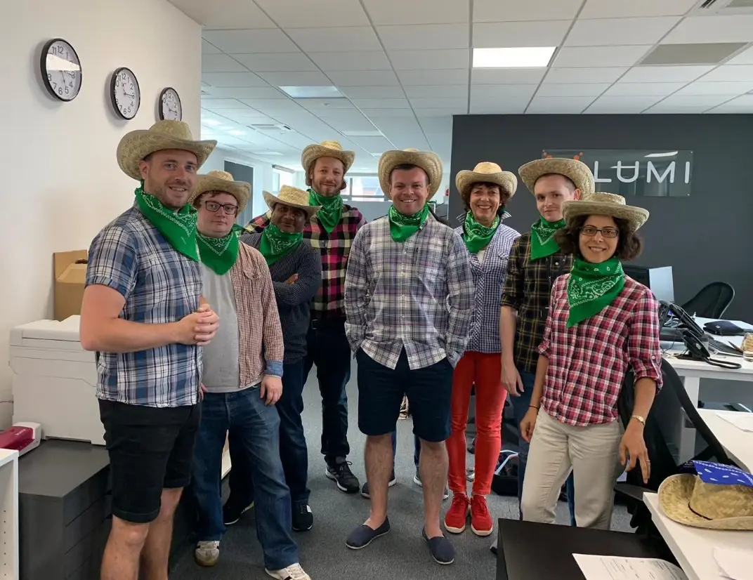 Employees in fancy dress with checked shirts, straw hats and neckerchiefs