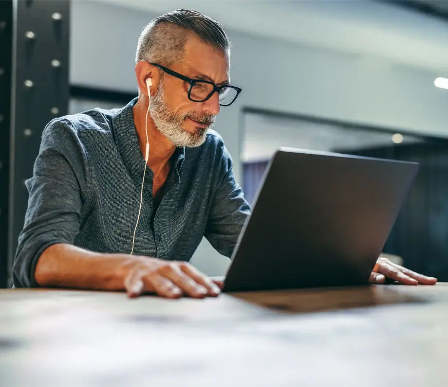 Man with headphones looking at a laptop